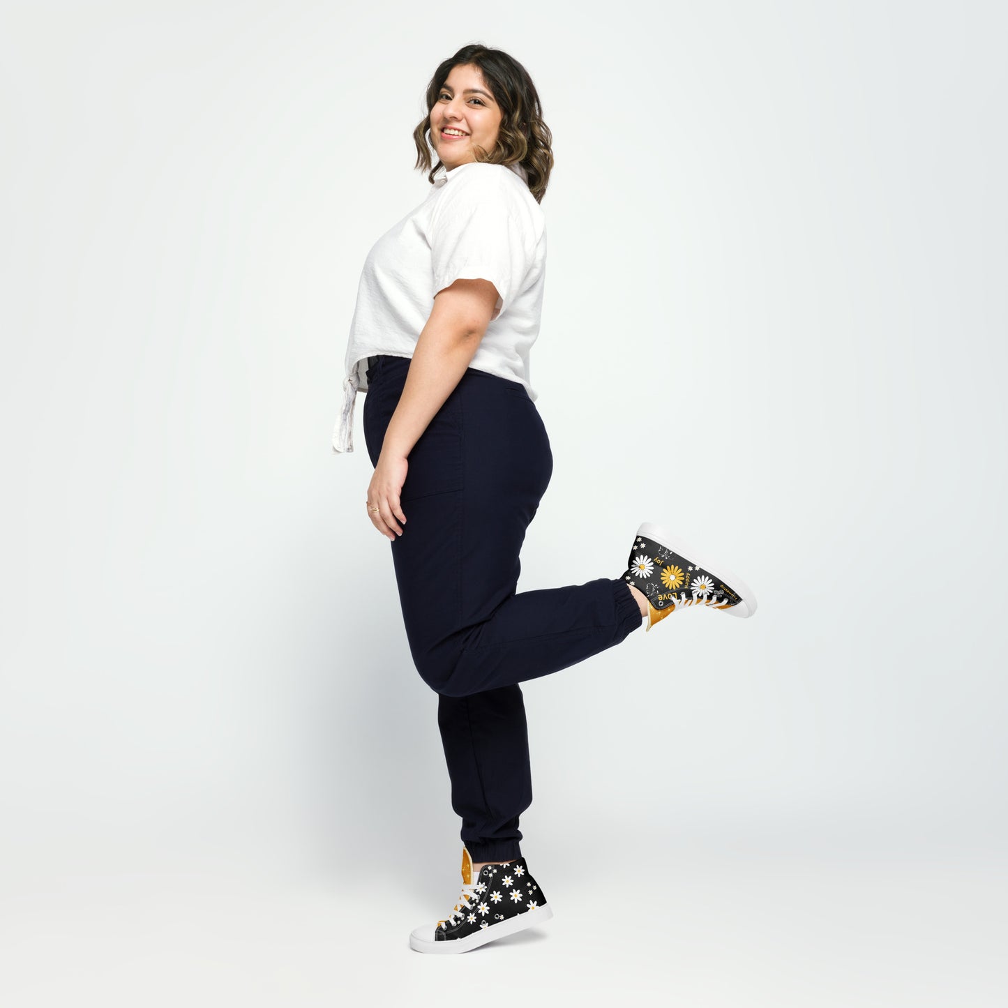 Women’s high-top Black canvas shoes whit yellow and white Daisy Flowers and swirls. The shoes have inspirational words – "friendship," "joy," "love," and "happy"
