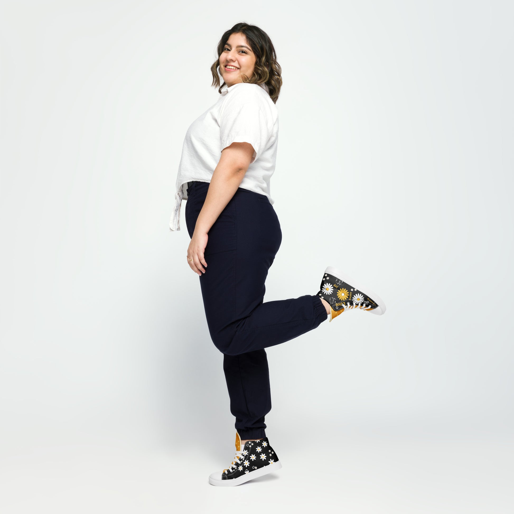 Women’s high-top Black canvas shoes whit yellow and white Daisy Flowers and swirls.  The shoes have inspirational words – "friendship," "joy," "love," and "happy"